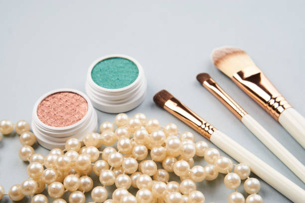 eyeshadow makeup brushes collection professional cosmetics accessories beads on gray background. High quality photo