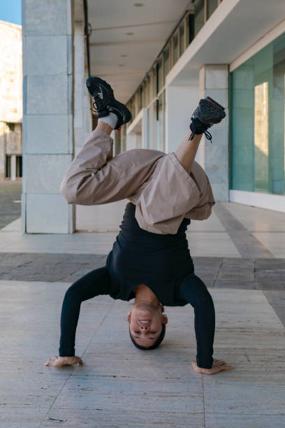 istock A young woman does a face down pose on a sidewalk breakdancing 2187015605
