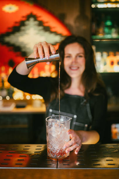 istock Young female bartender pouring cocktails in a cocktail bar 2187018278