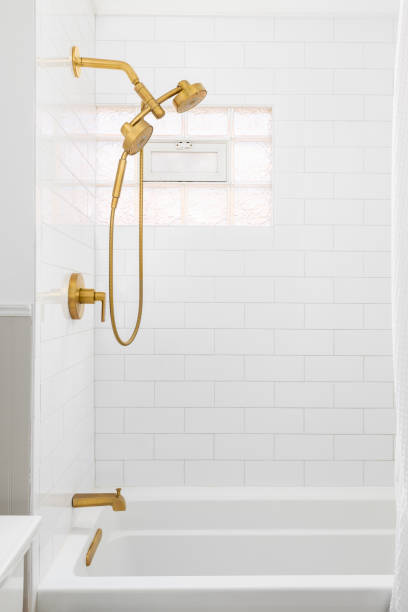 istock A bathroom shower with a white subway tile and gold faucet. 2187021628