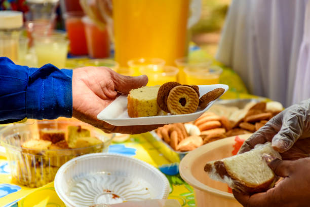 Person receiving various foods in a tray at a community breakfast