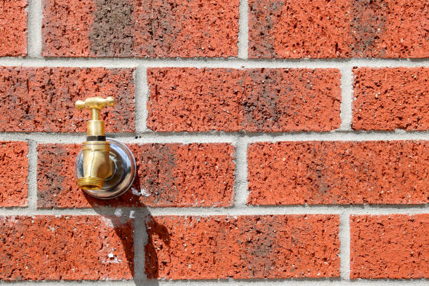 red brick wall with water tap