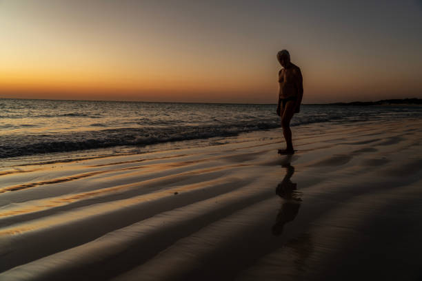 Senior men enjoying sunset on the wavy sandy beach at the sea. Deserted sandy beach, Ambatomilo,  Madagascar