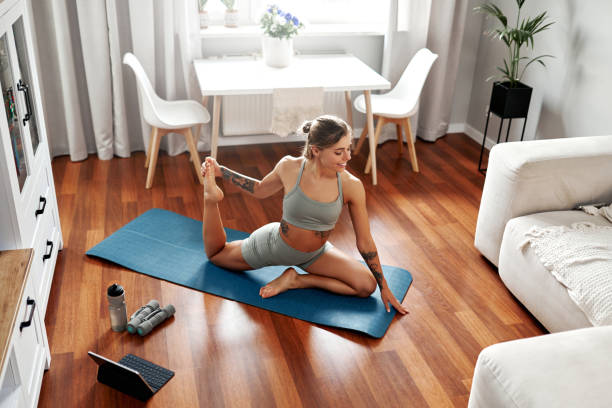 istock Woman Engaged in Practicing Yoga at Home with a Focused Flexibility Routine for Wellbeing 2187026399