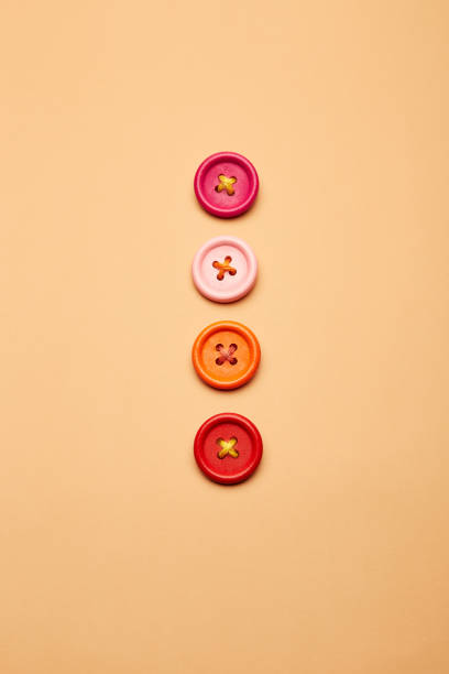istock Four lined up clothes sewing buttons on the sandy beige background 2187027277