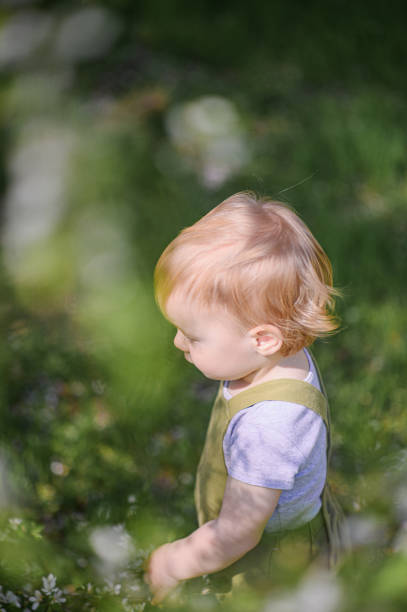 Happy Toddler Playing Outdoors in a Spring Garden.