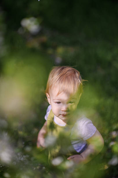 Happy Toddler Playing Outdoors in a Spring Garden.