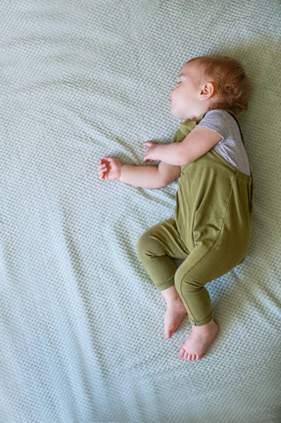 istock Sleeping Toddler on a Soft Green Blanket. 2187028650