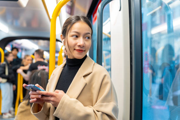 istock Asian woman using mobile phone on train. 2187031528
