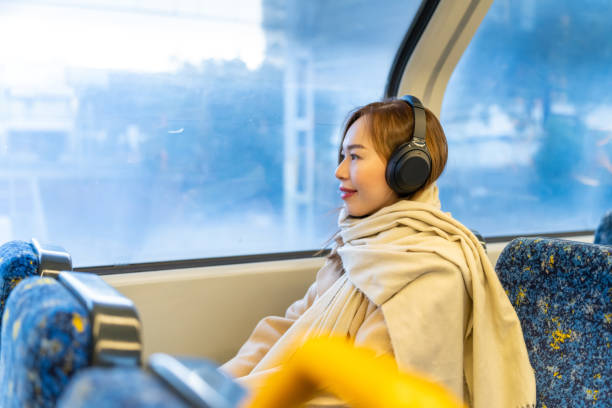 istock Asian woman using mobile phone on tram. 2187032351
