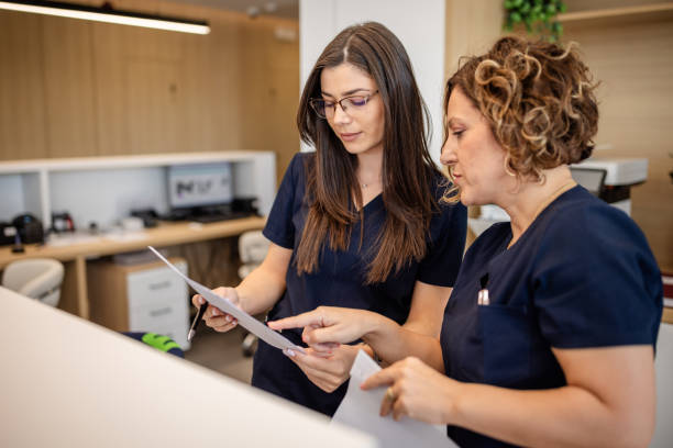istock Two nurses focused on paperwork in organized office. 2187039974