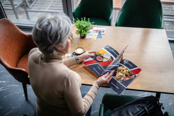 istock Senior enjoying menu exploration in urban coffee shop. 2187043377