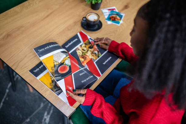 istock Young woman checking the menu to make food selection. 2187044910