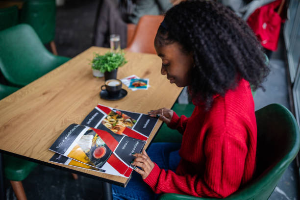istock Woman ponders over a menu in a cozy dining setting. 2187045077