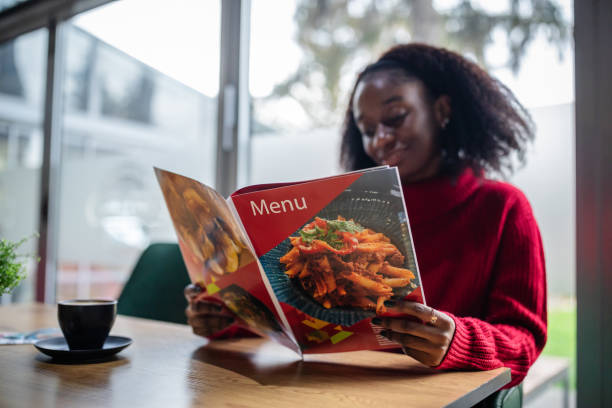 Elegant woman reviews menu thoughtfully over coffee.