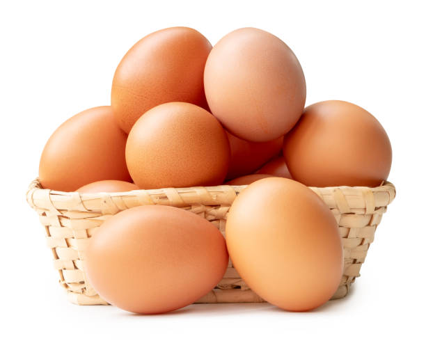 group of fresh brown chicken eggs in stack in wicker basket isolated on white background with clipping path - huevo etapa de animal fotografías e imágenes de stock
