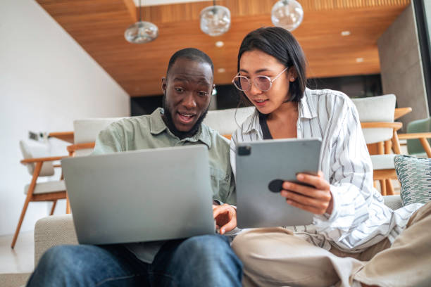 istock Diverse Duo Engaging with Tech in Cozy Living Space 2187047321