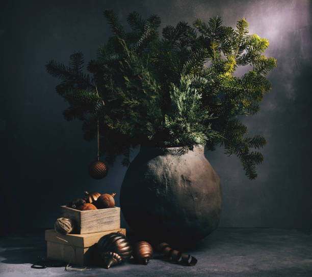 istock Pine tree branches in a rustic clay jar with vintage christmas ornament 2187049042