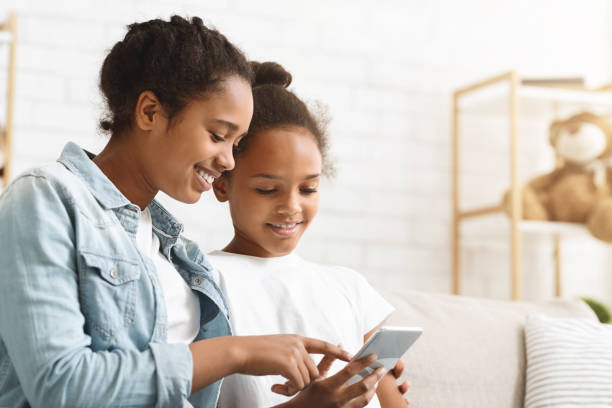 istock African sisters checking on new mobile application at home 2187050254