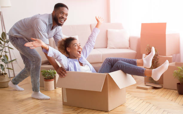 istock Happy Black Couple Having Fun Riding In Cardboard Boxes Indoor 2187051294