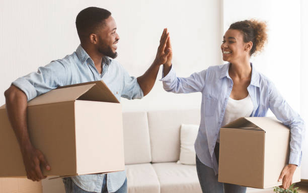 istock Black Spouses Giving High-Five Carrying Packed Boxes In New Apartment 2187051352