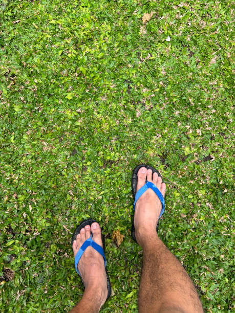 istock top view, two feet wearing green rubber sandals 2187053482