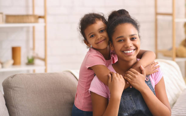 istock Happy african american sisters hugging at home 2187053556