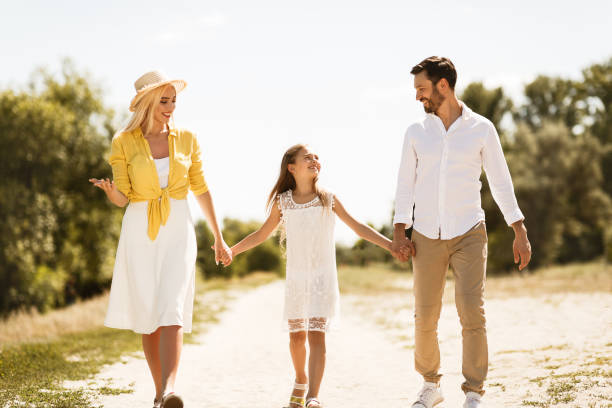 istock Happy family walking on path holding hands 2187055158