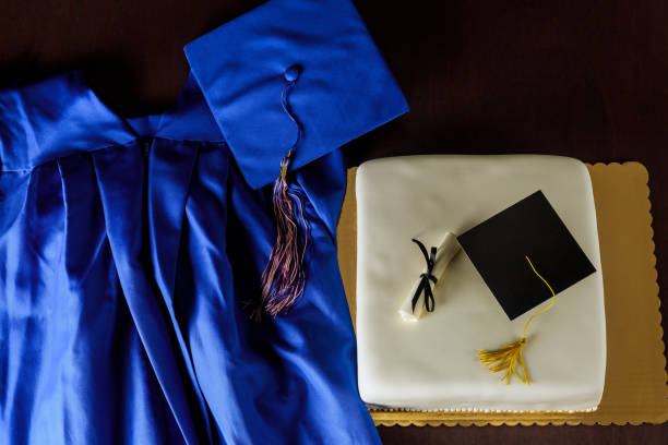 istock Graduation celebration with blue gown and decorated cake featuring caps and tassels 2187065540