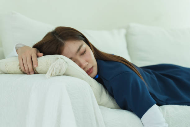 A tranquil scene of a young woman doctor resting on a cozy couch, enjoying a peaceful nap. The serene ambiance highlights relaxation and comfort in a domestic setting.