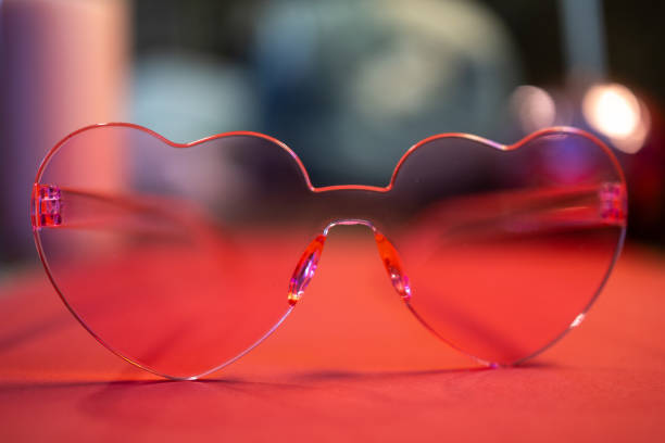 istock Heart-shaped pink glasses with a blurred colorful background 2187066330