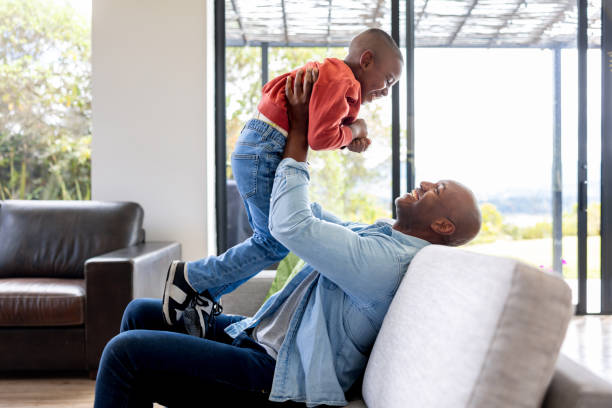 istock Playful father lifting his son while relaxing on the sofa 2187069436