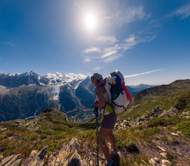 istock Woman hiking on mountain trail with backpack against scenic mountain backdrop 2187071463