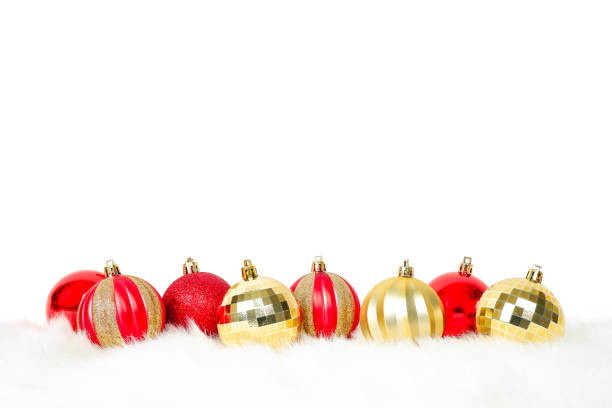 Red and gold Christmas balls ornaments placed on white fur on white background with copy space for text decoration , Merry Christmas and Happy new year festive concept
