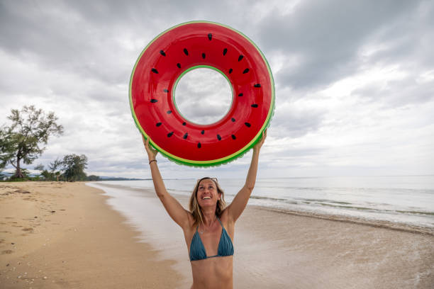 istock Woman at the Beach Holding Float Above Her Head 2187073221