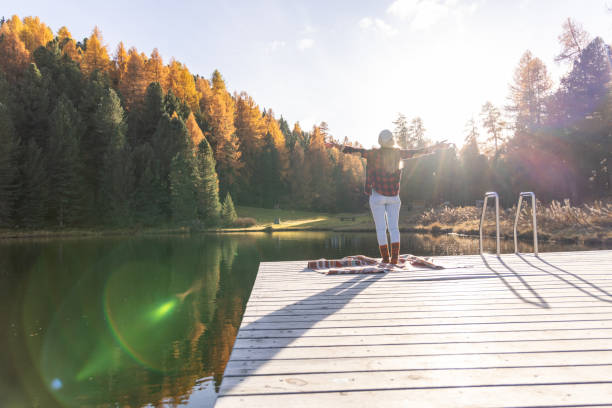 istock Woman Stretching on Dock Amidst Autumn Scenery 2187073665