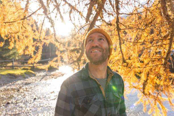 istock Man Admiring Autumn Leaves in Golden Light 2187073896