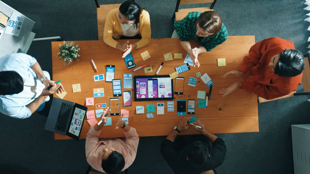 Top view of skilled business team writing idea on sticky note. Convocation.