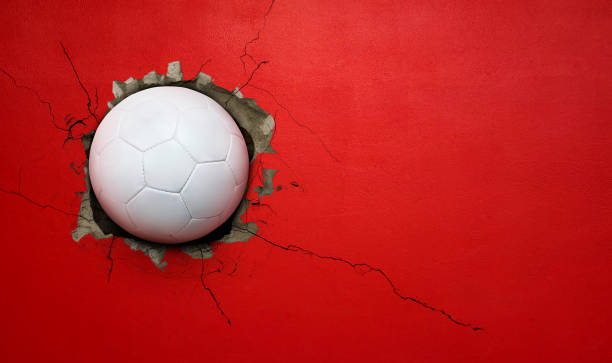istock Soccer ball breaks through red concrete wall, concept of power, strength. 2187080764