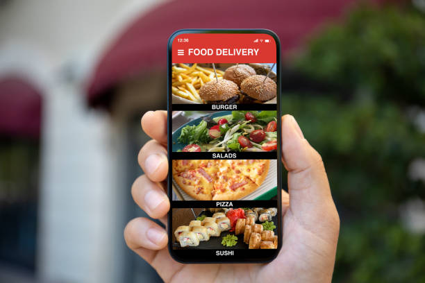istock Man hand holding phone with food delivery app on screen 2187081460