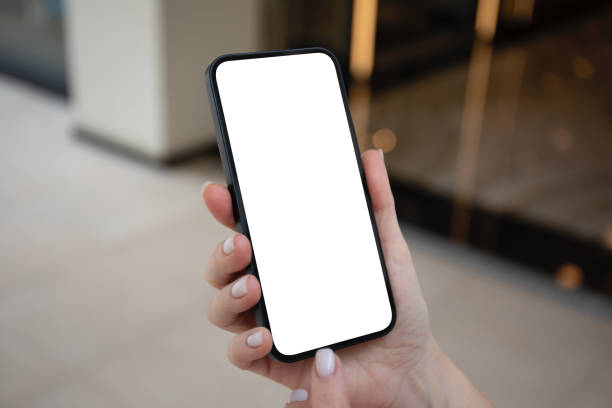 istock Female hands holding phone with isolated screen on background street 2187081476