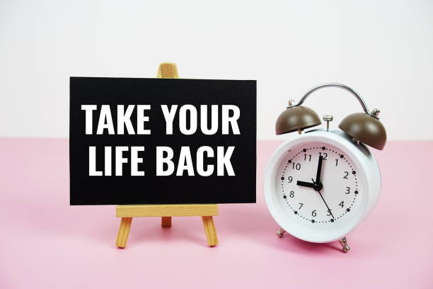 istock Take your life back text written on paper card with easel standing and alarm clock on pink background 2187082483