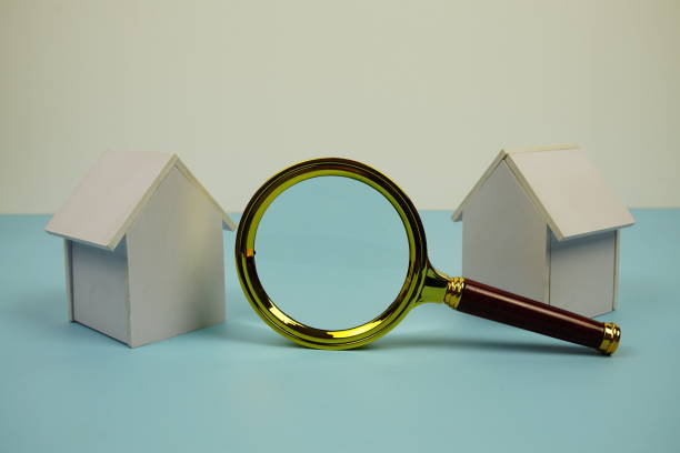 istock White Model House and magnifying glass with space copy on blue background 2187083633