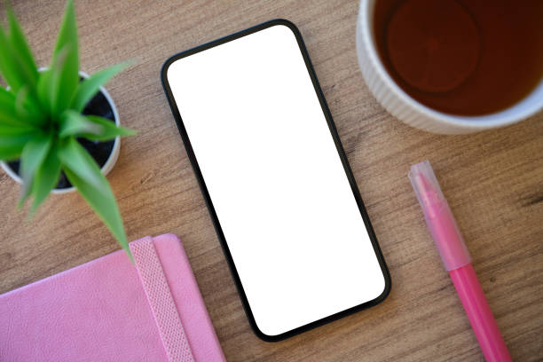 istock Phone with isolated screen background wooden table with pink notepad 2187083705