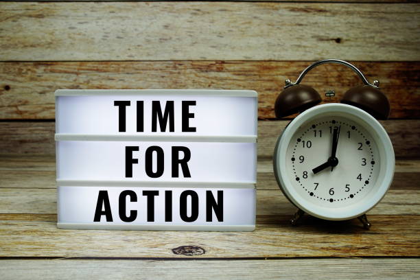 istock Time for Action text on LED lightbox with alarm clock on wooden background 2187083764
