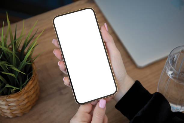 istock female hands holding phone with isolated screen background wooden table 2187083884