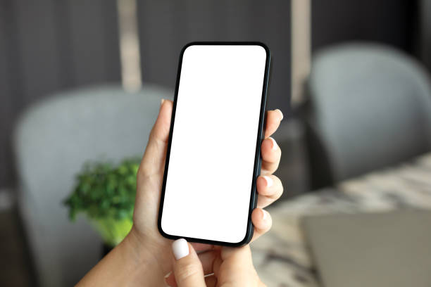 istock female hand holding phone with isolated screen background table office 2187083886