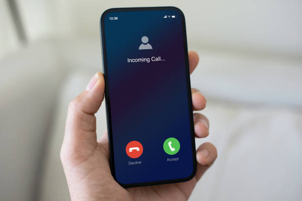 istock male hand holding phone incoming call on screen light room 2187083913
