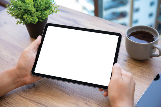istock male hands holding computer tablet isolated screen background wooden table 2187083936