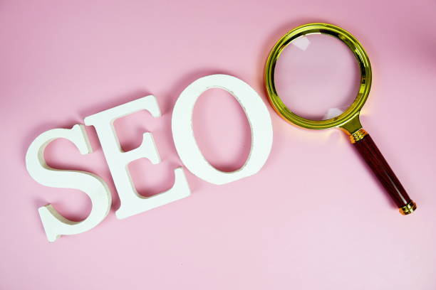 istock Seo words (Search Engine Optimization) letters with magnifying glass on pink background 2187084170